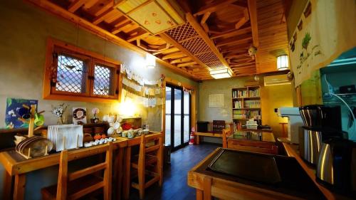 a large room with a kitchen with a counter and tables at Jeonju Hongsi Hanok Guesthouse in Jeonju