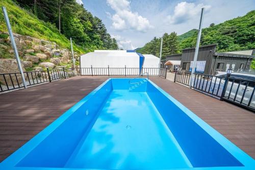 a large blue swimming pool on a wooden deck at Namyangju The Style in Anmasan