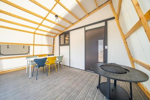 a room with a table and chairs on a deck at Namyangju The Style in Anmasan
