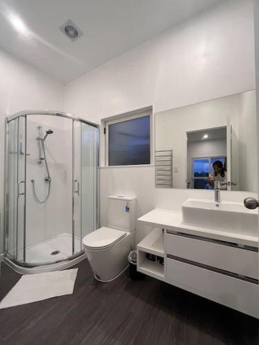 a bathroom with a shower and a toilet and a sink at U&U 2bedrooms Home in Whangaparaoa