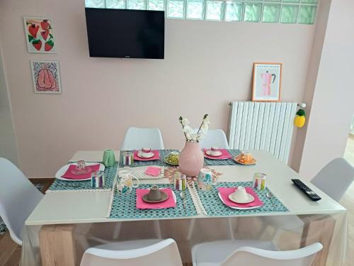 a dining room table with pink dishes and a vase at Villa MARGHERITA in Pratola Peligna