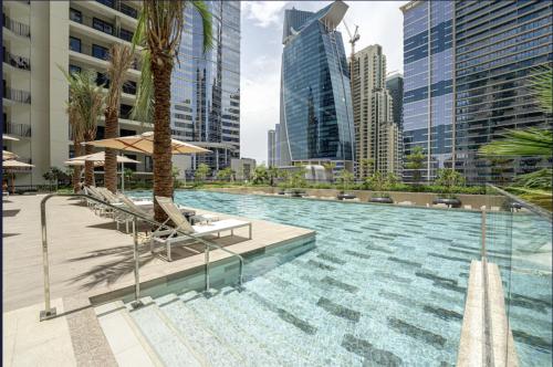 a swimming pool in a city with tall buildings at Modern High-Floor Apartment with Burj Khalifa View by Dejaview Stays in Dubai