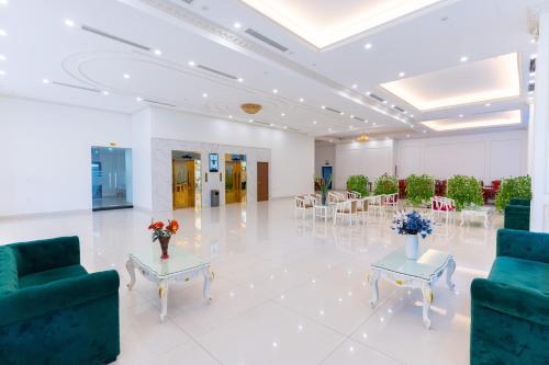 a large room with chairs and tables and flowers at Grand Hill Hotel & Apartment in Hai Phong
