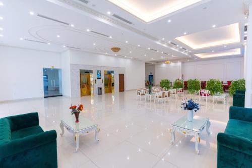 a large room with tables and chairs and a room with flowers at Grand Hill Hotel & Apartment in Hai Phong