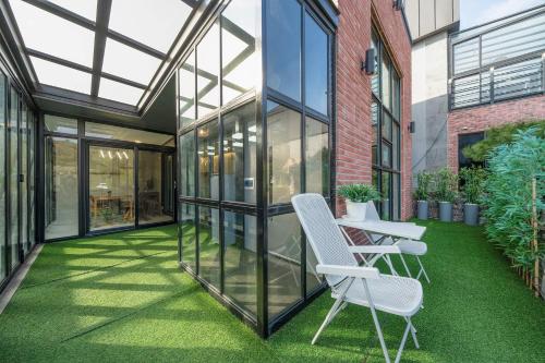 an internal courtyard of a building with two chairs and grass at Huerim Pool Villa Private Pension in Ch'ŏn'gun-ni