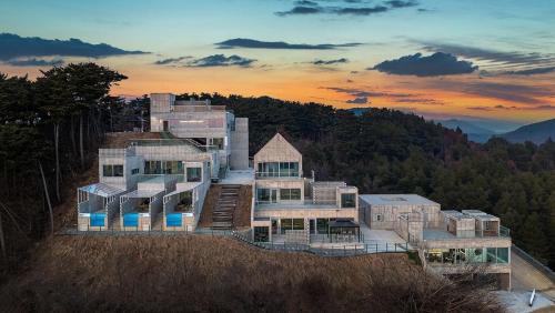 a large house on top of a hill at Taean Oaten Pool Villa in Taean