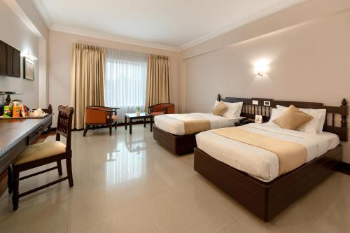 a hotel room with two beds and a kitchen at Hyson heritage calicut in Kozhikode