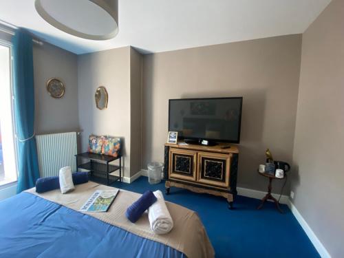 - une chambre avec un lit et une télévision sur une table dans l'établissement Le moulin de la Vernoelle, à Prémilhat