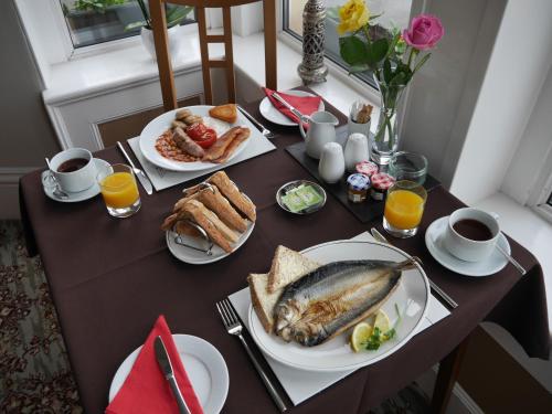 uma mesa com pequeno-almoço de pão, peixe e sumo de laranja em Redlands em Brixham