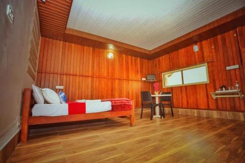 une chambre avec un lit dans un mur en bois dans l'établissement Vattakkuny Wild Orchid Resorts, à Thirunelli