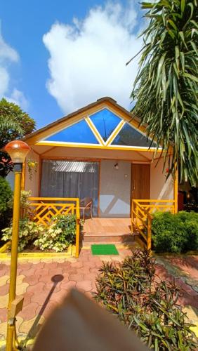 una casa con un porche con una palmera en Natures Dreamland Holiday Homes, Igatpuri, en Igatpuri