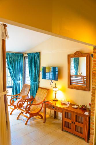 a living room with two chairs and a table at Hotel Deli River and Restaurant Omlandia in Medan