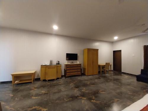 an empty room with a desk and a tv in it at Mango Valley Resort Ganpatipule in Ratnagiri
