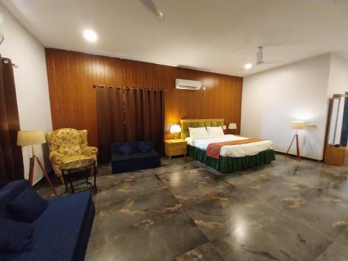a hotel room with a bed and a chair at Mango Valley Resort Ganpatipule in Ratnagiri