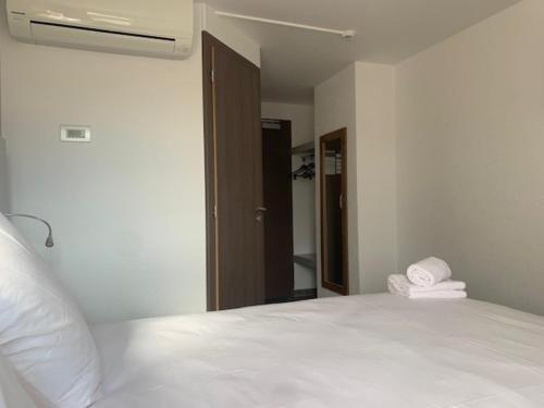 a bedroom with a white bed and a mirror at Val Hôtel Montbéliard Sud in Valentigney