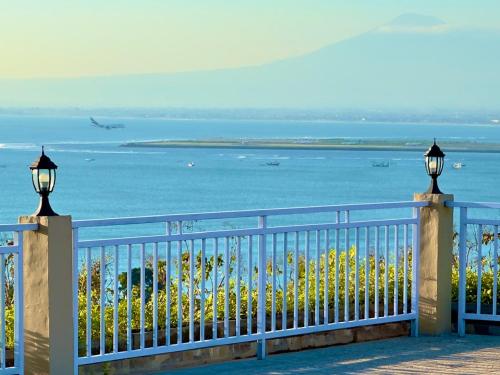 a fence with a view of the ocean and a plane at The Pandan Sari Hotel in Jimbaran