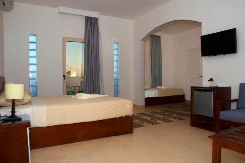 a hotel room with a bed and a television at Elaria Hotel Hurgada in Hurghada