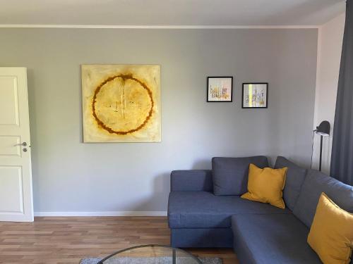 a living room with a blue couch and a clock on the wall at James -Ferienwohnung mit Balkon in Strand und Wald Nähe in Flensburg