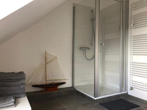 a bathroom with a glass shower with a boat on the wall at Nordic Living - 90m² im nordisch modernen Stil in Flensburg