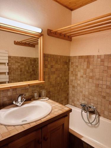 une salle de bain avec un lavabo, un miroir et une baignoire dans l'établissement Blanches Alpes Appartement Megève, à Megève