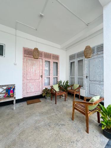 a living room with chairs and tables and windows at Gypsea' Madiha in Matara