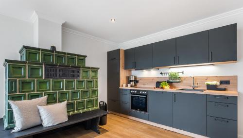 a kitchen with black and green cabinets and a bench at Bali -Habernis, direkt an der Ostsee in Steinberg