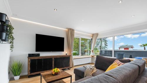 a living room with a couch and a flat screen tv at Bali -Habernis, direkt an der Ostsee in Steinberg