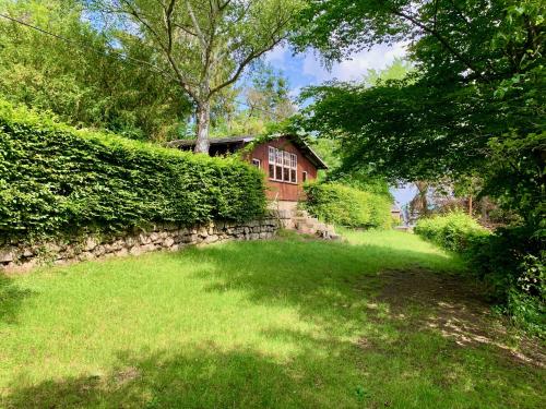 a yard with a stone wall and a house at Evangelisches Allianzhaus in Bad Blankenburg