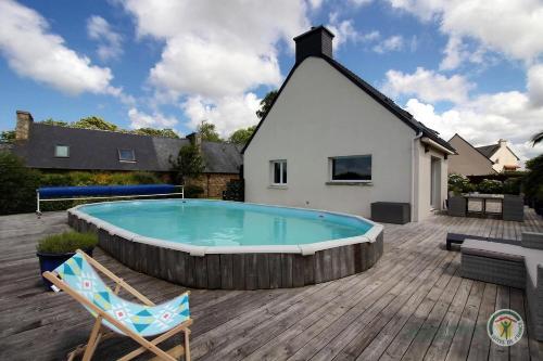 - une piscine avec une chaise et une maison dans l'établissement Ty morgwen, à Kermaria-Sulard