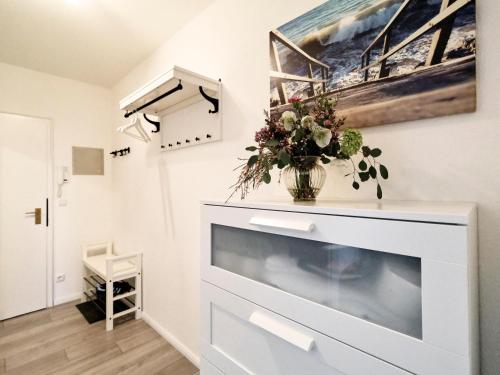 a living room with a fireplace and a painting on the wall at Küstenliebe -mit traumhaftem Meerblick und Balkon in Flensburg
