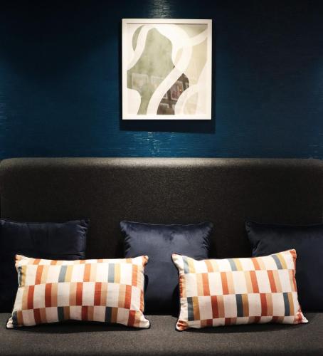a bed with two pillows in front of a blue wall at Garner Hotel Preston Samlesbury by IHG in Preston