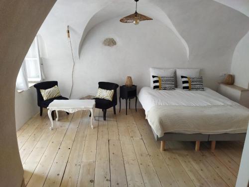 a bedroom with a bed and a table and chairs at Les studettes du Beffroi in Cucuron