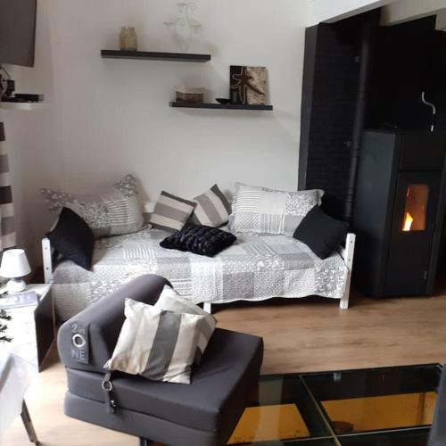 un salon avec un canapé et une chaise dans l'établissement La Cabourotte, ancien fournil, classé 3 étoiles, à Herpelmont