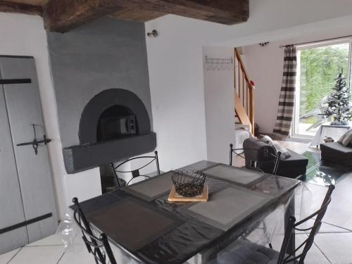 un salon avec une table et une cheminée dans l'établissement La Cabourotte, ancien fournil, classé 3 étoiles, à Herpelmont