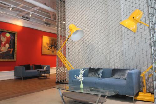 a living room with a blue couch and a table at Beat Hotel Bangkok in Bangkok