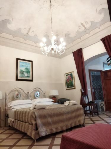 a bedroom with two beds and a chandelier at B&B Cribò in San Giuliano Terme
