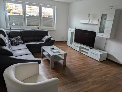 a living room with a couch and a tv at Schöne einfache Ferienwohnung zwischen Stadt und Meer in Wilhelmshaven