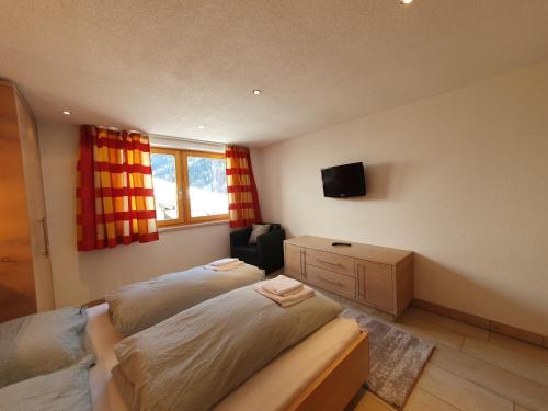 a bedroom with two beds and a tv on the wall at Apart Kathrein in Mathon
