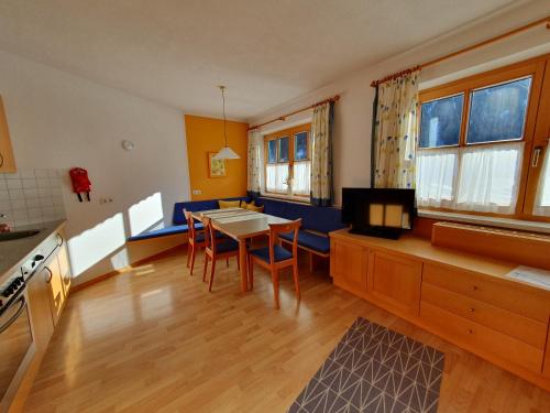 a kitchen with a table and chairs in a room at Apart Kathrein in Mathon