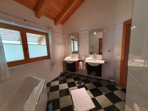 a bathroom with two sinks and a tub and mirrors at Apart Kathrein in Mathon