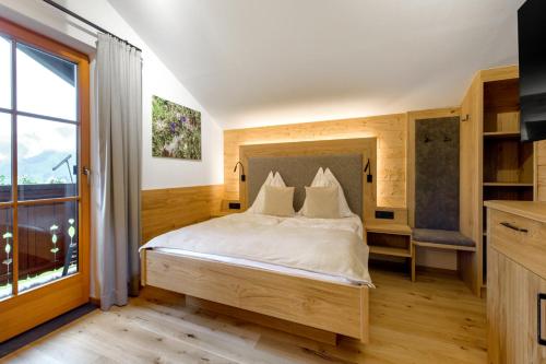 a bedroom with a bed and a large window at Bauernhof Auhof in Wagrain