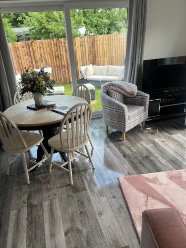a living room with a table and chairs at Gladstone cottage in Rocester