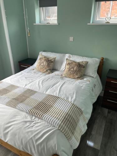 a large white bed with two pillows on it at Gladstone cottage in Rocester