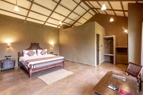 a large bedroom with a bed and a table at Sterling Orient Woods Pench in Silāri