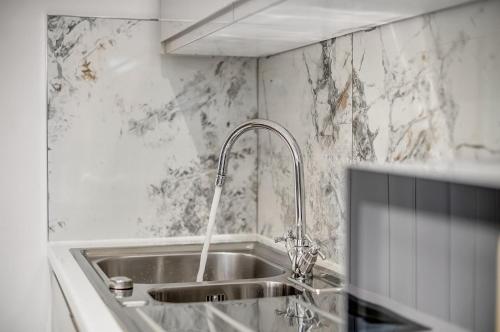 a kitchen with a sink with a faucet at Cowley Oxford Stay - Spacious 4 Bed House in Oxford