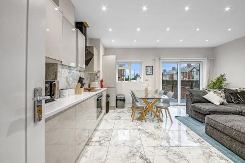 a kitchen and living room with a couch and a table at Cowley Oxford Stay - Spacious 4 Bed House in Oxford