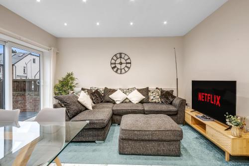 a living room with a couch and a tv at Cowley Oxford Stay - Spacious 4 Bed House in Oxford