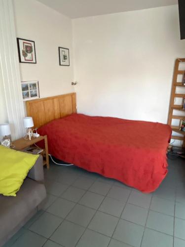 1 dormitorio con cama roja y sofá en la rafale, en Fort-Mahon-Plage