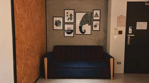 a blue couch in a room with pictures on the wall at Chill Roof Hotel in Taipei