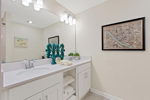 基西米Tranquility At Storey Lake By Shine Villas #828的一间白色浴室，配有洗手池和镜子。